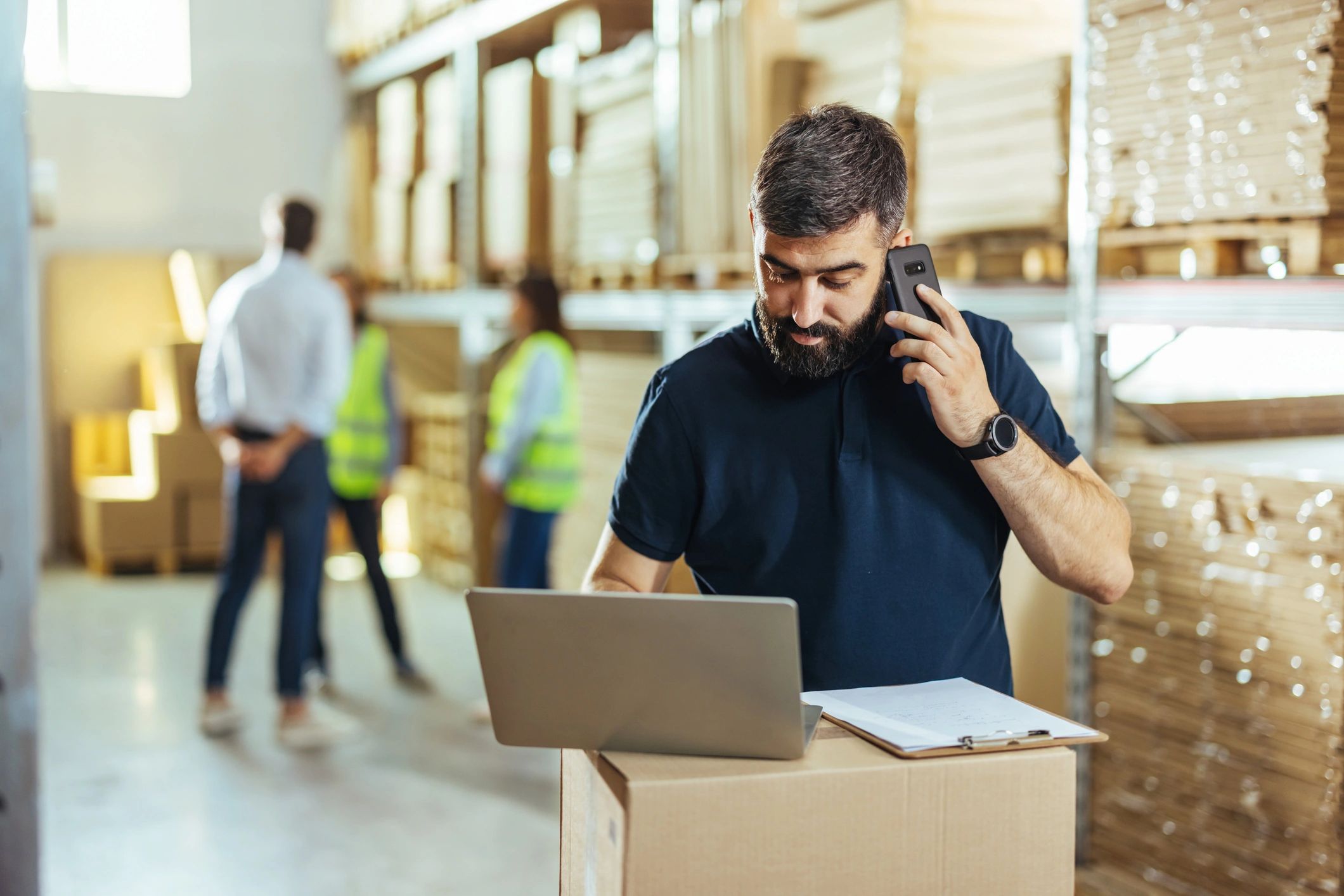 Warehouse worker using a laptop in a distribution warehouse